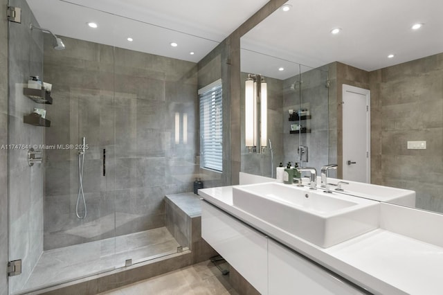 bathroom with tile walls, vanity, and an enclosed shower