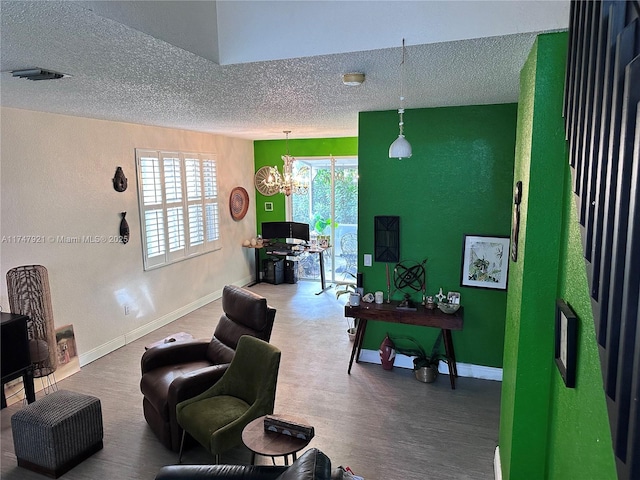 living room with a textured ceiling, a notable chandelier, and wood-type flooring