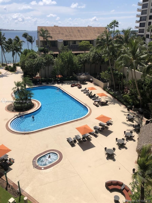 view of pool with a patio and a water view