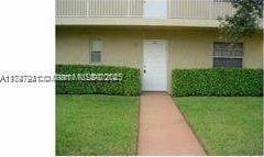 entrance to property featuring a lawn