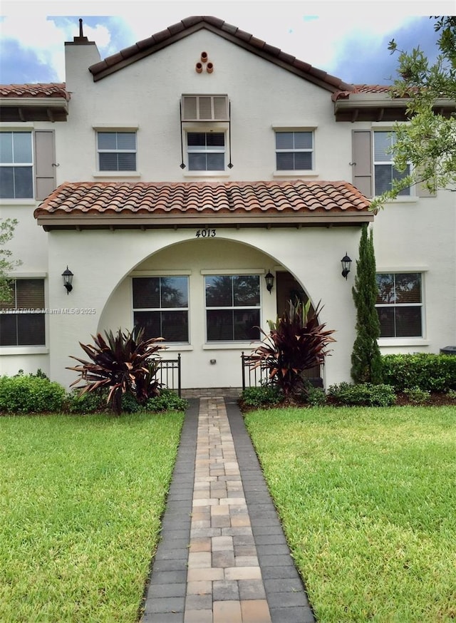 mediterranean / spanish home featuring a front lawn