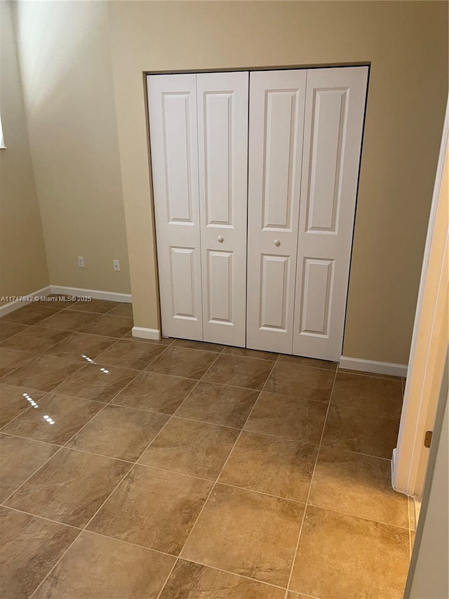 unfurnished bedroom featuring tile patterned floors and a closet