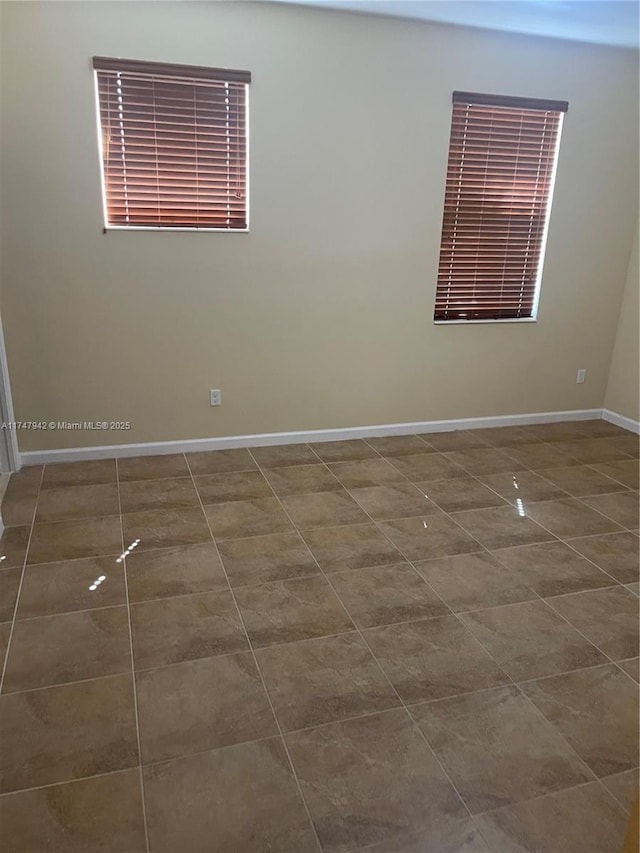 unfurnished room featuring dark tile patterned floors