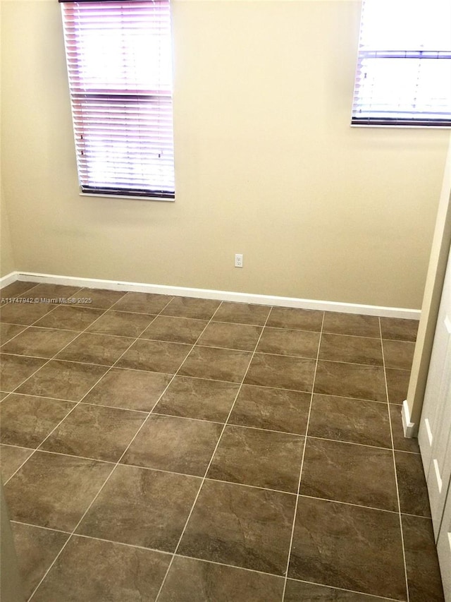 unfurnished room featuring dark tile patterned flooring