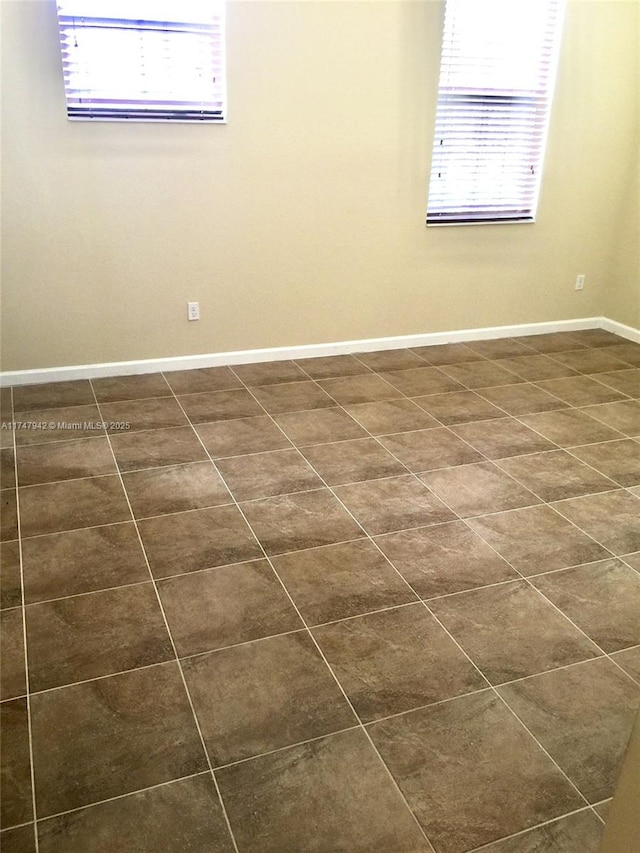 tiled empty room featuring a healthy amount of sunlight