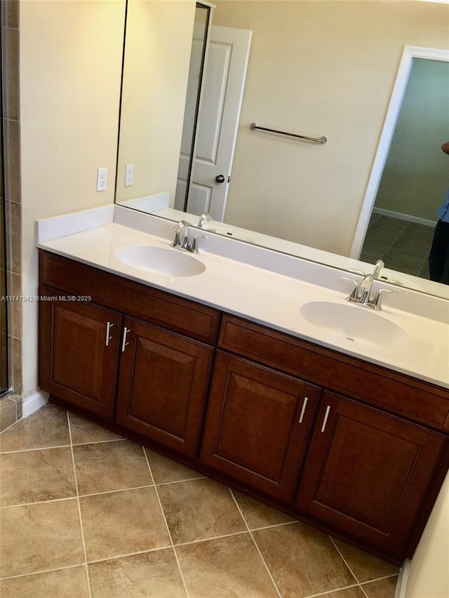 bathroom with tile patterned flooring, vanity, and walk in shower