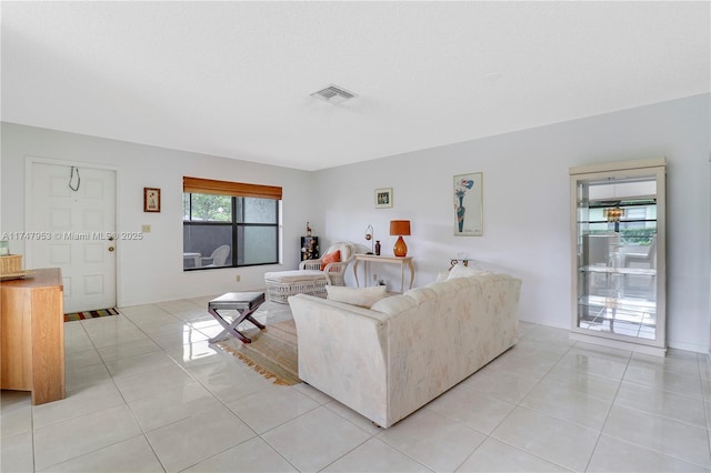 living area featuring visible vents and light tile patterned flooring