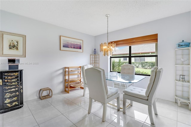 dining room with a textured ceiling, light tile patterned floors, and an inviting chandelier