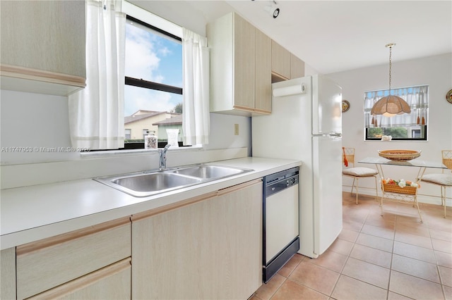 kitchen featuring white dishwasher, light countertops, a sink, and light tile patterned flooring