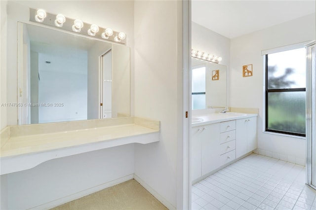 full bath featuring double vanity, baseboards, and a sink