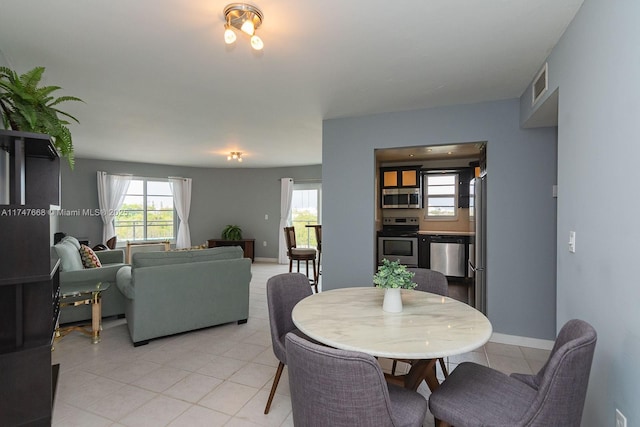 dining space featuring light tile patterned floors and plenty of natural light