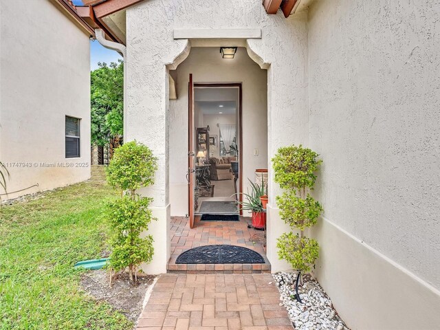 property entrance featuring a patio area and a yard