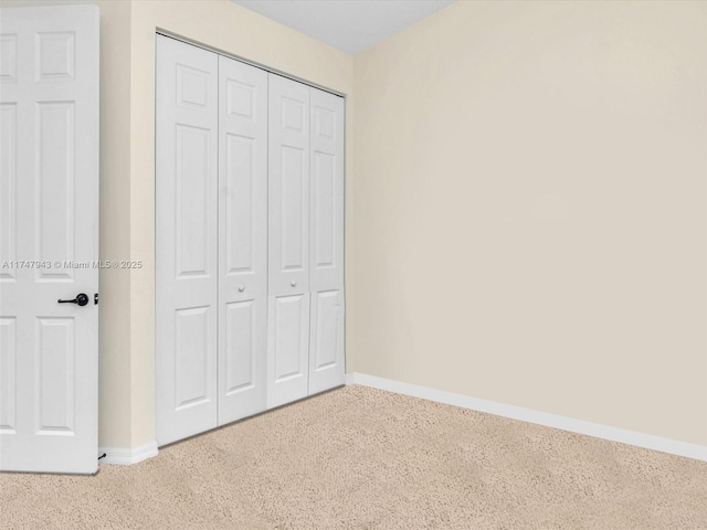 unfurnished bedroom featuring carpet and a closet