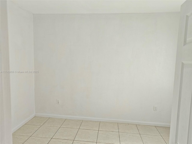 spare room with light tile patterned floors and baseboards