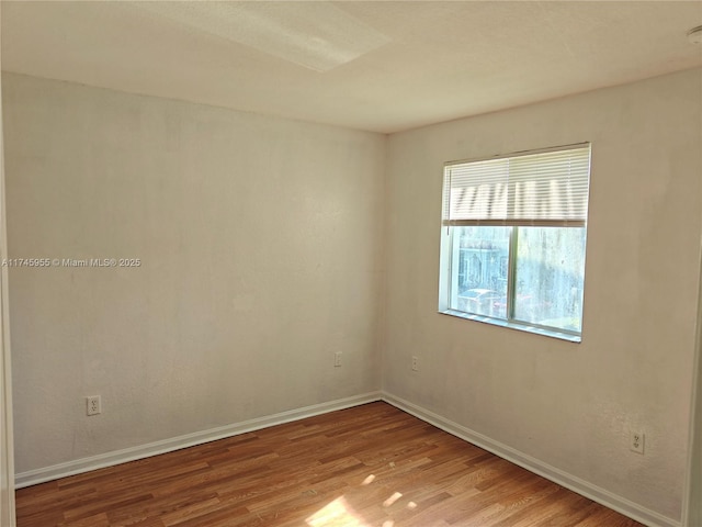 unfurnished room with baseboards and light wood-style floors