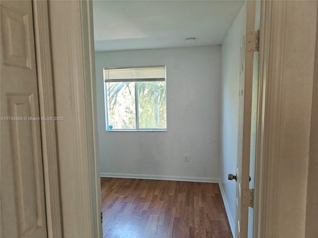 unfurnished bedroom with dark wood-style floors and baseboards