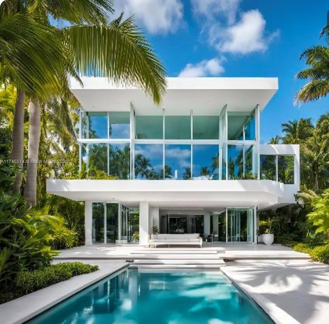 rear view of house featuring a patio area and an outdoor pool