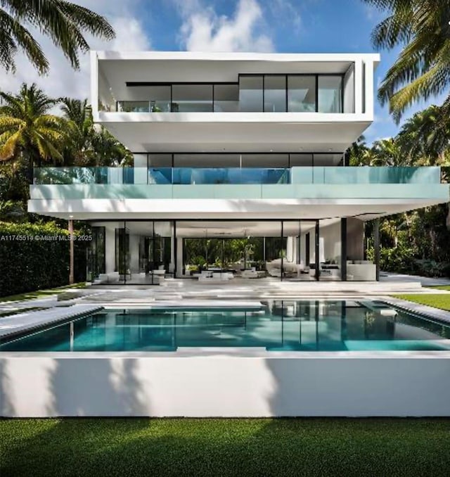 back of property with an outdoor pool, a patio, and stucco siding