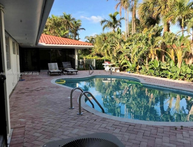 outdoor pool featuring a patio area and fence