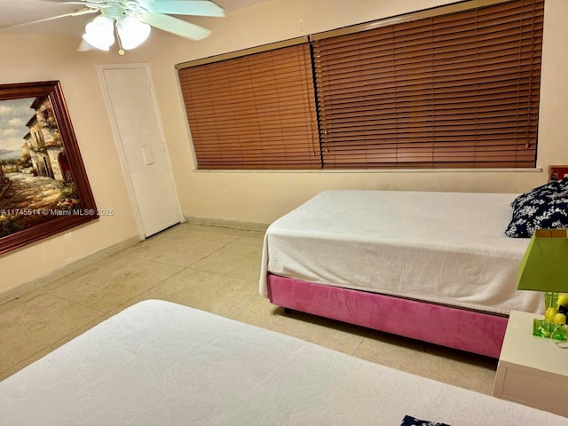 bedroom with ceiling fan and baseboards