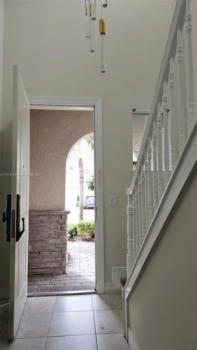 entrance foyer featuring stairway and light tile patterned floors