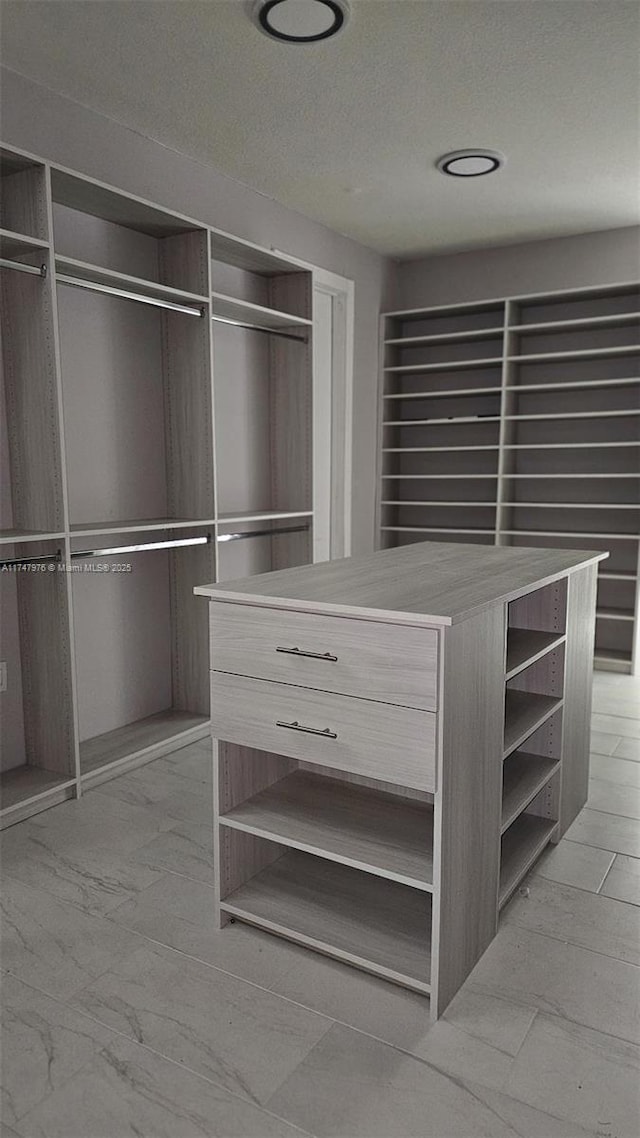 spacious closet featuring marble finish floor