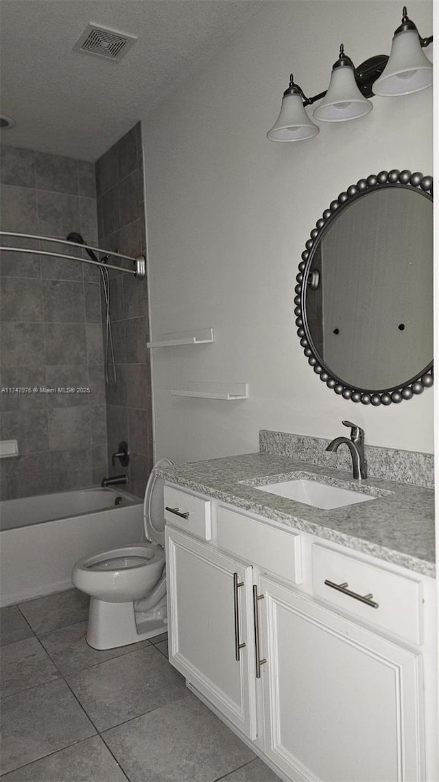 full bath featuring visible vents, shower / bath combination, toilet, vanity, and tile patterned flooring