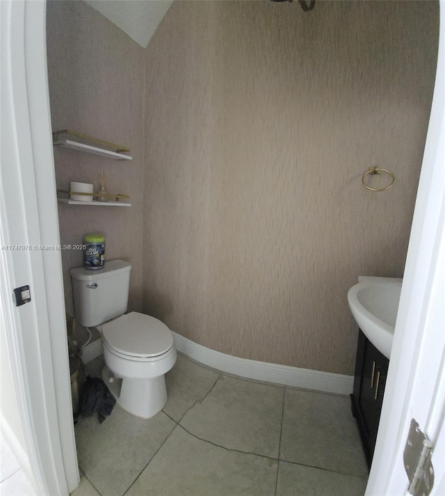 bathroom featuring toilet, baseboards, and tile patterned floors