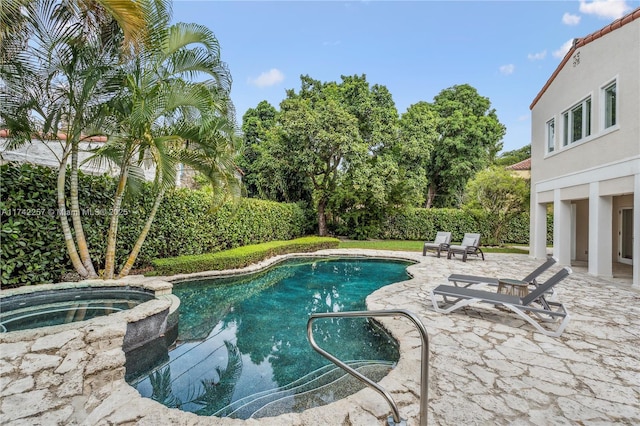 view of swimming pool with a patio and a pool with connected hot tub