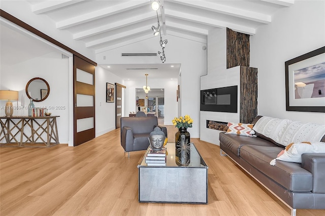 living room with light wood-style floors and lofted ceiling with beams