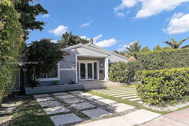 back of property with french doors and stucco siding