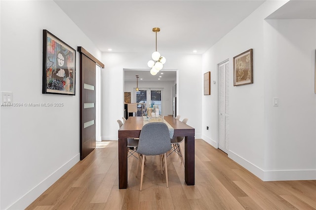 dining room featuring recessed lighting, baseboards, light wood finished floors, and a barn door