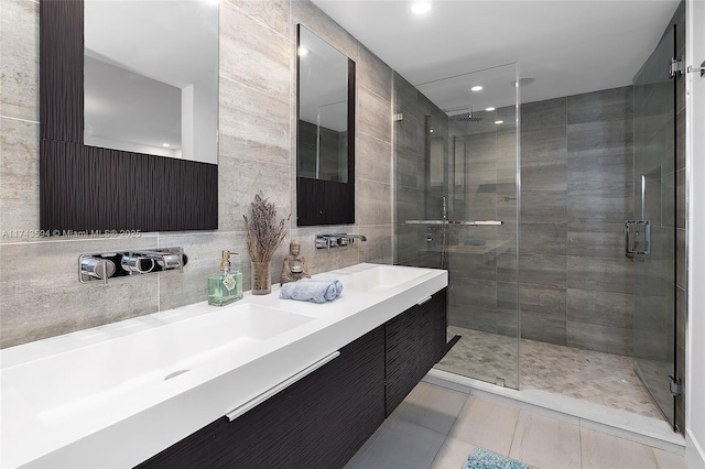 bathroom featuring tile walls, tile patterned flooring, vanity, a shower stall, and backsplash