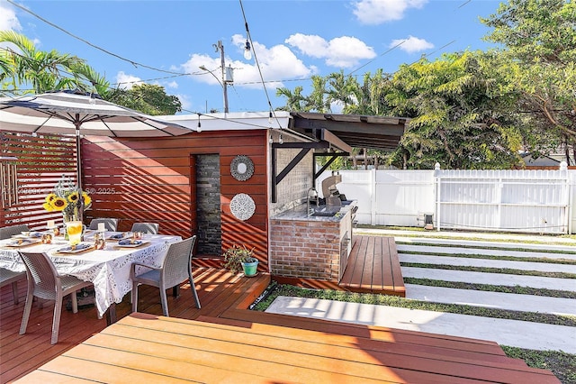 wooden terrace with outdoor dining area and fence