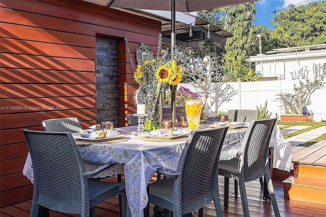 deck with outdoor dining area and fence