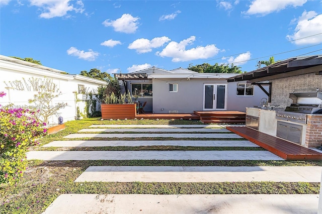 exterior space featuring french doors, a wooden deck, and stucco siding