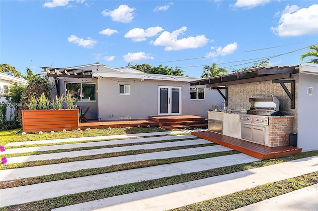 back of house featuring stucco siding, a deck, area for grilling, and french doors