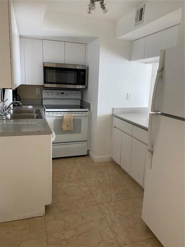 kitchen featuring sink, white appliances, and white cabinets