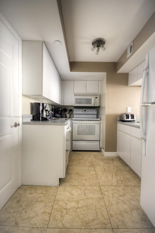 kitchen with white cabinetry and white appliances