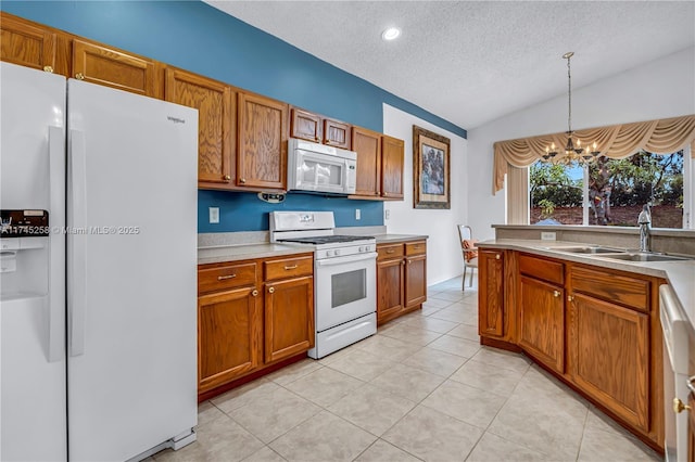 kitchen with white appliances, lofted ceiling, pendant lighting, a chandelier, and sink