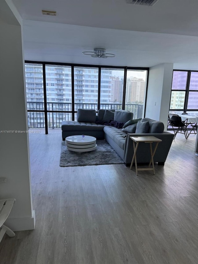 living area featuring ceiling fan, a view of city, visible vents, and wood finished floors