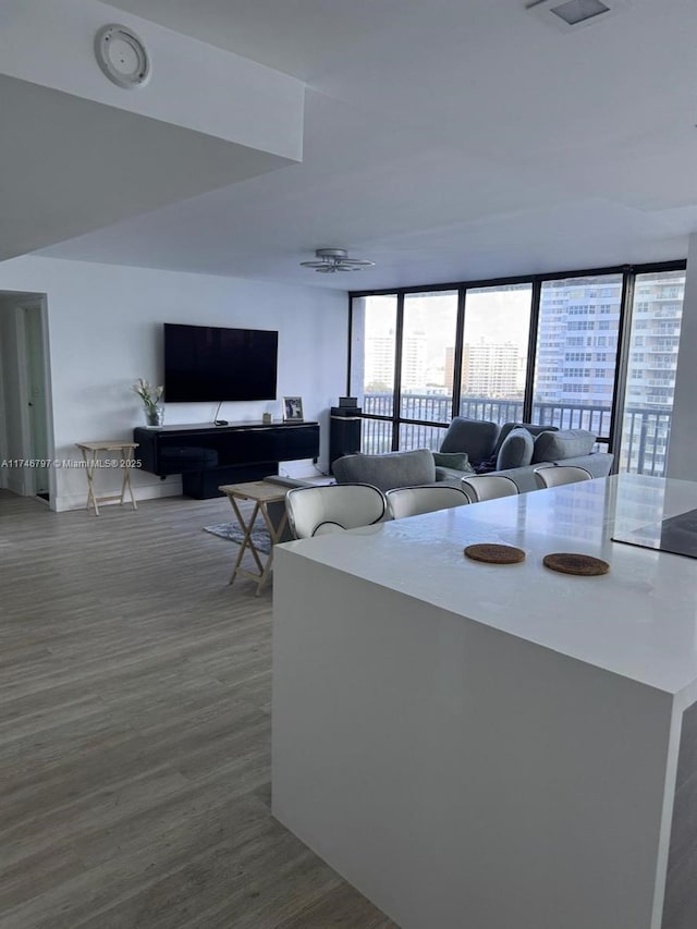 living room with expansive windows, hardwood / wood-style flooring, and ceiling fan