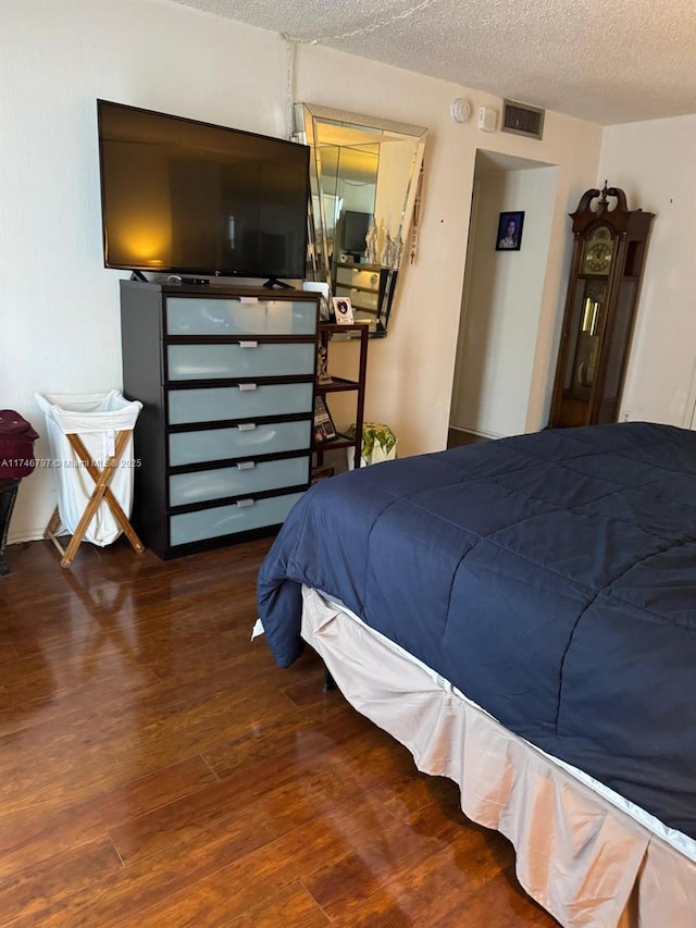 bedroom featuring hardwood / wood-style flooring and a textured ceiling