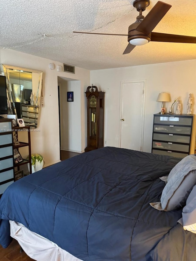 bedroom featuring ceiling fan and a textured ceiling