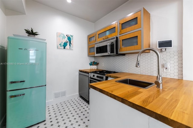 kitchen featuring appliances with stainless steel finishes, sink, and decorative backsplash