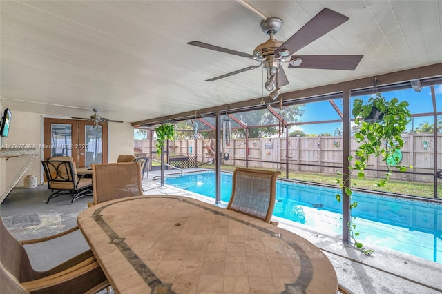 view of swimming pool with a patio, glass enclosure, and ceiling fan