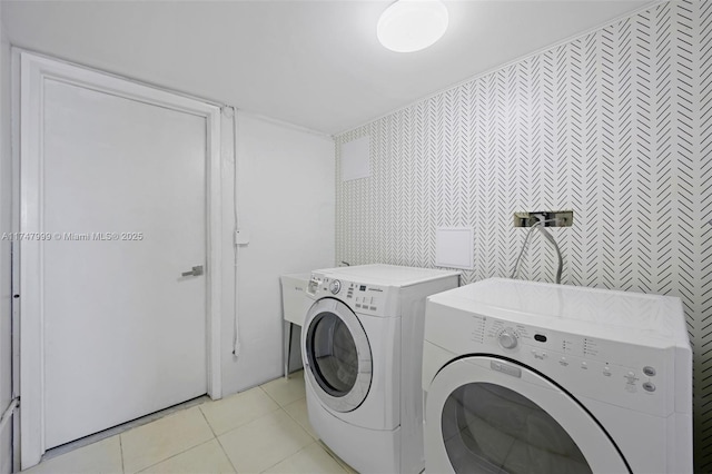 clothes washing area with light tile patterned floors and washer and dryer