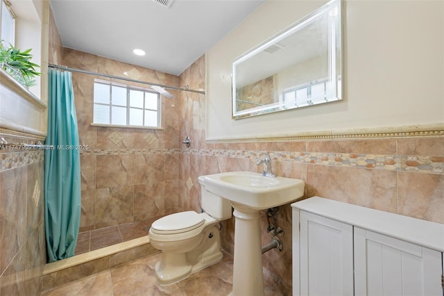 bathroom featuring tile walls, sink, toilet, and walk in shower