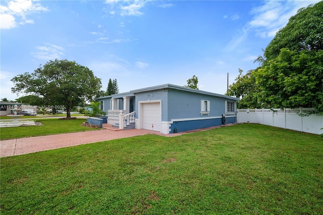 view of front of home with a front yard and a garage