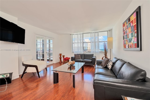 living room with french doors, a wall of windows, plenty of natural light, and wood-type flooring